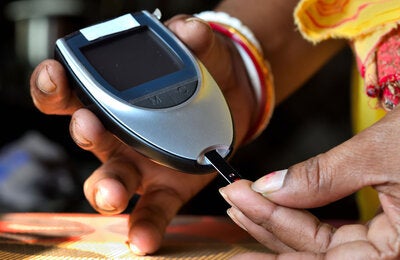 Woman testing blood sugar level