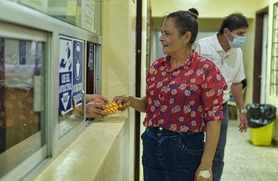 Paciente recibe sus medicamentos en farmacia hospitalaria