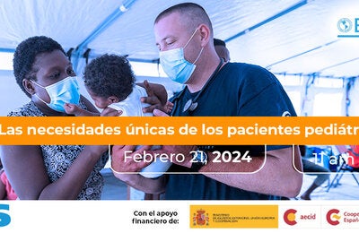 Una madre y un personal de primera línea de respuesta, sosteniendo a un bebé dentro de un hospital móvil