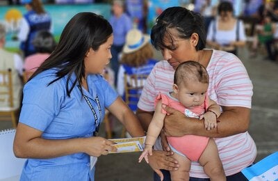 Enfermera junto a madre y niño vacunado