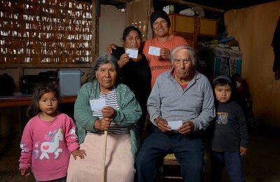 family holding up their vaccination cards at home