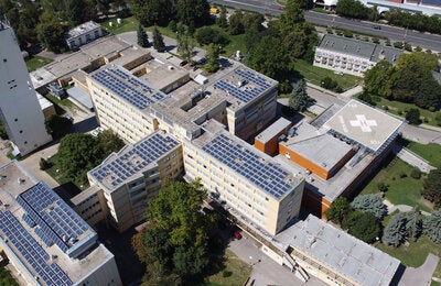Hospital renovable. Edificios hospitalarios con vista aérea y paneles solares en el techo de una bonita zona verde.