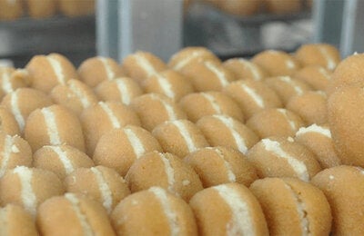 baking sheet full of cream-filled sugar-coated fried pastries
