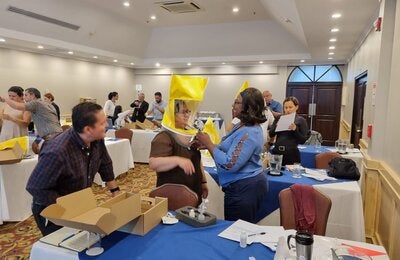 Large event room. Participants are learning how to use personal protection equipment on a respiratory protection training