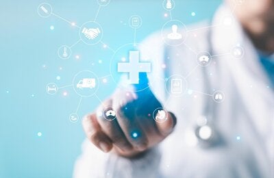 burred photo of the body of a health provider pointing at icons representing health