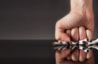 puño aplastando cigarrillos