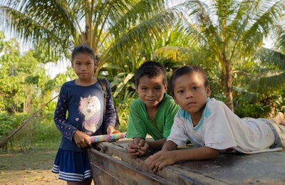 Una niña y dos niños en una zona costanera