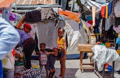 Children smile at camera at a camp in Haiti