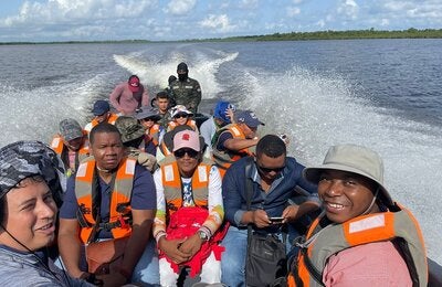 Misión de malaria y equipo local viaja en lancha a visitar comunidades