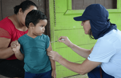 Un niño recibiendo en su casa la dosis pendiente de la vacuna contra sarampión, rubéola y paperas