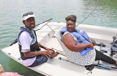 Two people in a boat preparing to sail
