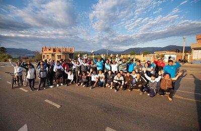 imagen de un grupo de personas con las manos levantadas en señar de victoria, en un paisaje rural.