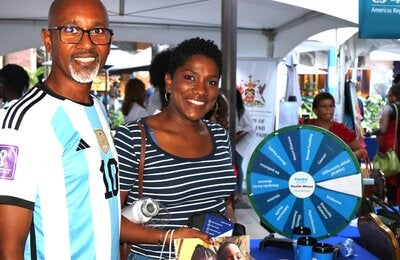 A couple at the PAHO/WHO TTO booth at the UNDP Caravan