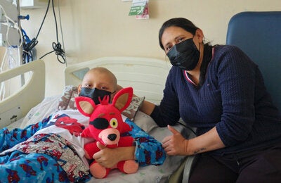 Mother with son, who is in a hospital bed