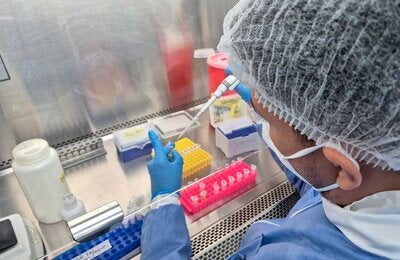 Bacteriologa en el laboratorio realizando pruebas en na pipeta