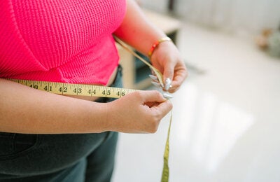 Woman measuring her waist 