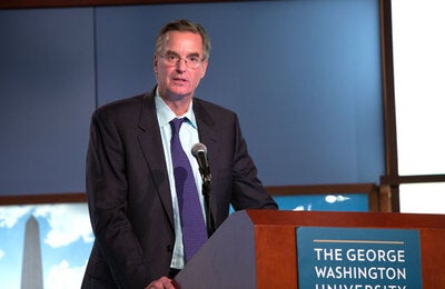 Dr. Anderson speaks behind a podium at GWU