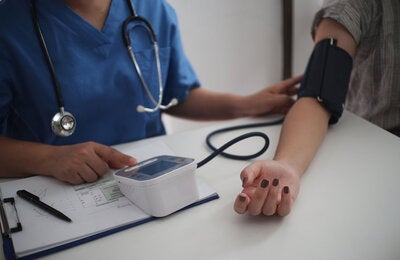 Nurse measuring blood pressure of patient