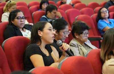 participante del taller sujeta el micrófono para tomar la palabra
