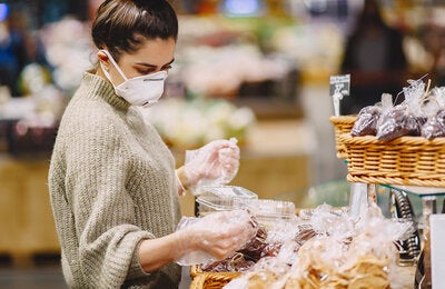 mulher de máscara fazendo compras
