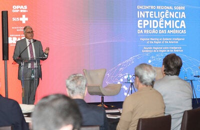 Representante da OPAS no Brasil fala ao microfone para a plateia