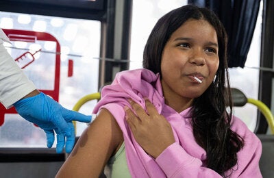 Mujer colocando el braso para la vacuna de fiebre amarilla