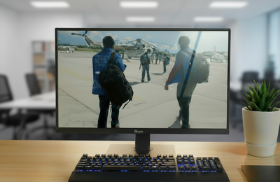Monitor de computadora con foto de dos hombres con chalecos de OPS, en el fondo se ve un helicóptero