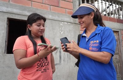 Miembros de la parroquia José Luis Tamayo comparten mensajes sobre salud y la prevención de la DCI usando una llamada de celular para que sea transmitido por los parlantes de la comunidad.
