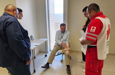 Persona realiza primeros auxilios a un maniquí bebé