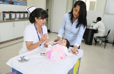 Enfermera vacuna a bebé