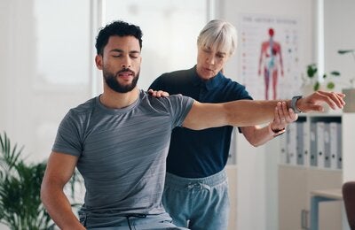 Brazo elástico, fisioterapia y consulta al paciente por problemas, inflamación o artritis. Persona, quiropráctico y ejercicio para dolor de lesión, rehabilitación y recuperación del músculo articular