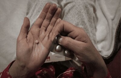 manos muestran un blíster de medicamentos