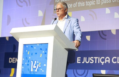 Representante da OPAS, vestido com terno azul claro, fala no púlpito durante abertura do Abrascão
