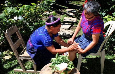 Terapeuta maya da un masaje a mujer q'anjob'al