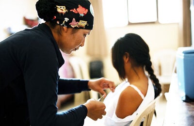 Health care worker applying a vaccine to a girl