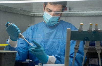 technician in protective gear testing and tracking down viruses