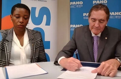 Photo Caption: (L-R) Dr. Rhonda Sealey-Thomas Assistant Director of the Pan American Health Organization witnesses the signing of the Framework Agreement by Dr. Jarbas Barbosa, PAHO Director