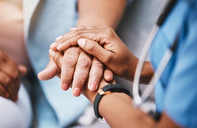 Health worker holding the hand of a patient