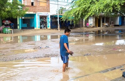 hombre en medio de un charco de agua provocada por las lluvias