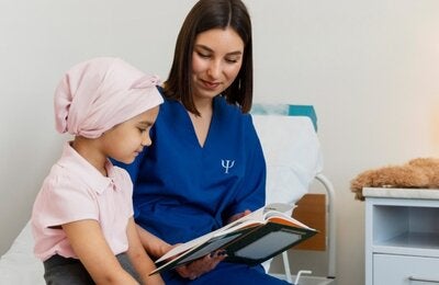 personal de salud mostrándole un libro a una niña con cáncer