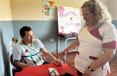 A healthcare worker measures and records a community member’s blood pressure at a health facility in Paraguay.