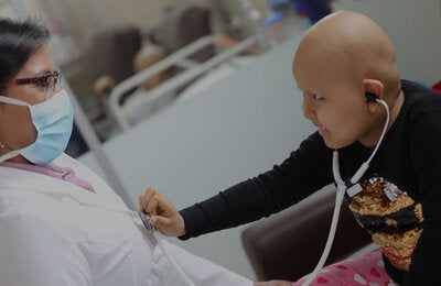 child with cancer interacting with doctor
