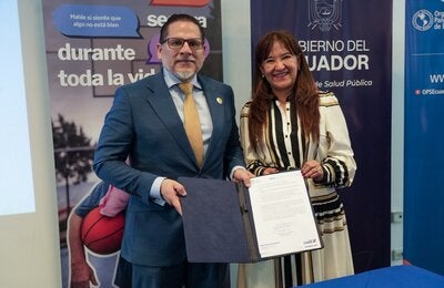 Ministro de Salud Pública, Juan Carlos Aveiga, junto a Sonia Quezada, representante de OPS/OMS Ecuador; muestra documento de Adhesión a la Iniciativa "Mejor Atención a las Enfermedades No Transmisibles".