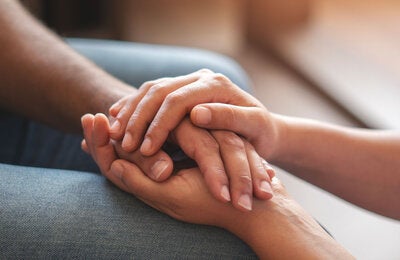  62 Una persona le ofrece apoyo a otra sosteniéndole las manos.