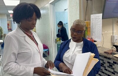 Two health workers review documents at a health center.