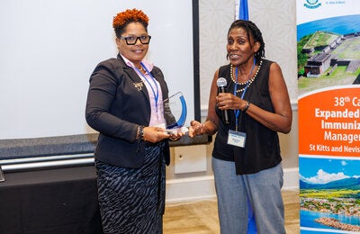 Beryl Irons presenting the inaugural award named in her honour to Grenada's EPI Manager, Hannah St. Paul