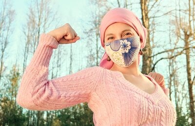 Woman making gesture indicating fighting against cancer
