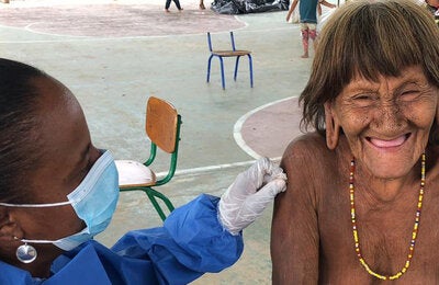Indigenous woman get vaccinated against COVID-19