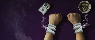 las manos de un adolescente atrapadas en el humo de cigarrillos
