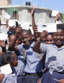 children holding up their vaccination cards